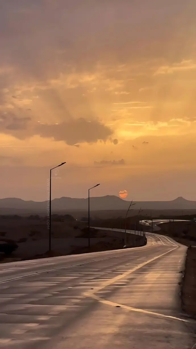 Classic galvanized steel street lighting poles on a desert road during golden sunset – ideal for highway and urban lighting projects.