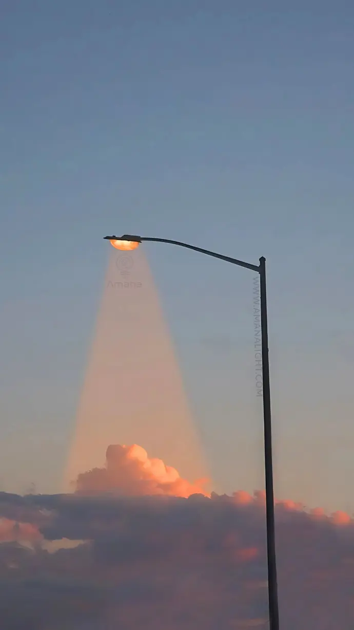 Classic LED street lighting pole illuminating clouds at dusk – galvanized steel design for urban and public road use.
